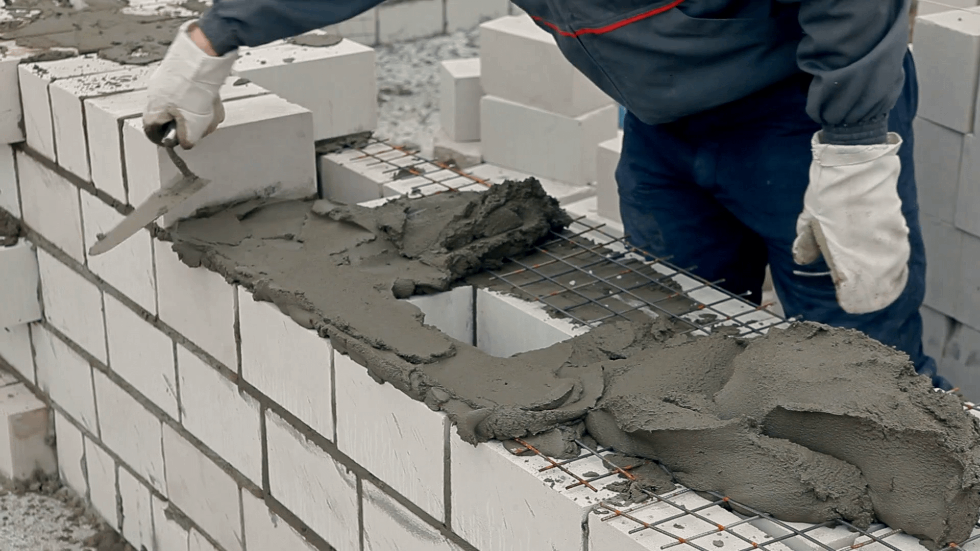 builders-are-constructing-a-multi-storey-brick-house-in-a-cold-winter-they-are-stacking-bricks-using-cement-spatulas_vrnoifgrg_thumbnail-1080_01